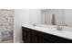 Double vanity bathroom with dark brown cabinets and marble shower at 2089 Camden Loop, Davenport, FL 33837