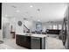 Open kitchen with island and stainless steel appliances, overlooking living room at 2089 Camden Loop, Davenport, FL 33837