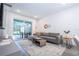 Living room with gray sectional sofa and sliding glass doors leading to pool area at 2595 Santorini Dr, Kissimmee, FL 34747