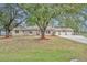 Single-story home with stone accents, mature trees, and a three-car garage at 2770 Windsong Ln, St Cloud, FL 34772