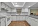 Bright kitchen features white cabinets, gray backsplash, and wood-look floors at 2770 Windsong Ln, St Cloud, FL 34772