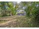 Backyard with some grass, trees, and the house visible at 3115 Avenue U Nw, Winter Haven, FL 33881