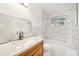 Modern bathroom with marble-style tiling, wood vanity, and shower at 3115 Avenue U Nw, Winter Haven, FL 33881