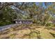 Quaint single-story home with a concrete driveway, set amid mature trees at 3115 Avenue U Nw, Winter Haven, FL 33881