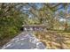 Quaint single-story home with a concrete driveway, set amid mature trees at 3115 Avenue U Nw, Winter Haven, FL 33881