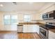 Bright kitchen featuring stainless steel appliances, granite counters, and white cabinetry at 3115 Avenue U Nw, Winter Haven, FL 33881