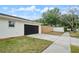 Attached garage with a modern black door and ample driveway space, adding convenience and curb appeal at 3138 Lakemar Ln, Orlando, FL 32806