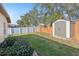 Backyard with green grass, shed, white vinyl fence, and partial brick fence at 369 Belhaven Falls Dr, Ocoee, FL 34761