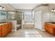 Bright bathroom with a glass-enclosed shower and a soaking tub beneath a window at 369 Belhaven Falls Dr, Ocoee, FL 34761