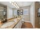 Bathroom featuring double granite vanity and a large framed mirror with decorative lighting at 369 Belhaven Falls Dr, Ocoee, FL 34761