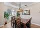 Bright dining room with a coffered ceiling, large window, and modern light fixture at 369 Belhaven Falls Dr, Ocoee, FL 34761