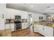 Modern kitchen featuring white cabinets, stainless steel appliances, and a granite countertop at 369 Belhaven Falls Dr, Ocoee, FL 34761