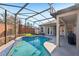 Backyard featuring screened pool with brick perimeter and outdoor kitchen at 369 Belhaven Falls Dr, Ocoee, FL 34761