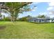 Expansive backyard featuring a screened-in porch, a lush lawn and mature trees at 4154 Equestrian Ln, Windermere, FL 34786