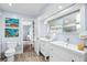 Bright bathroom features double sink vanity, wood-look floors, and coastal art at 4154 Equestrian Ln, Windermere, FL 34786