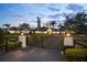 Gated driveway leading to an expansive single story home with a lush, well-manicured front lawn at 4154 Equestrian Ln, Windermere, FL 34786