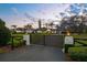 Elegant gated entrance leading to a beautiful estate, featuring lush landscaping and mature trees at 4154 Equestrian Ln, Windermere, FL 34786