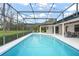 A stunning in-ground pool is enclosed in a screen and accented with string lights for evening enjoyment at 4154 Equestrian Ln, Windermere, FL 34786
