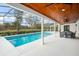 Gorgeous screened-in pool with an attached entertaining area featuring a wood plank ceiling and outdoor dining at 4154 Equestrian Ln, Windermere, FL 34786