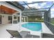 A lounging area adjoins the large in-ground pool, which is screened and enhanced with string lights at 4154 Equestrian Ln, Windermere, FL 34786