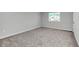Bedroom with neutral carpet, base trim, and a window letting in natural light at 4298 Campsite Loop, Orlando, FL 32824