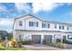 Two story townhome with gray garage doors and landscaping at 4298 Campsite Loop, Orlando, FL 32824