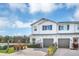 Two-story townhome with gray garage doors and landscaping at 4298 Campsite Loop, Orlando, FL 32824