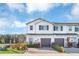 Two-story townhome with gray garage doors and landscaping at 4298 Campsite Loop, Orlando, FL 32824