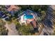 Aerial view of community pool near townhomes with tile roofs surrounded by lush landscaping at 4765 Capri Pl # 209, Orlando, FL 32811