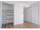 A view of a closet with white shelving, and laminate wood flooring at 4765 Capri Pl # 209, Orlando, FL 32811