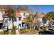 View of the building exterior featuring mature landscaping and reserved parking spaces at 4765 Capri Pl # 209, Orlando, FL 32811
