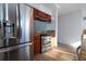 Stainless steel refrigerator and oven in kitchen with brown cabinets and wood-look flooring at 4765 Capri Pl # 209, Orlando, FL 32811