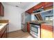 Kitchen featuring stainless steel refrigerator and oven, wood cabinets, and granite countertops at 4765 Capri Pl # 209, Orlando, FL 32811