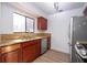 Bright kitchen featuring wood cabinets, stainless steel dishwasher, and light countertops at 4765 Capri Pl # 209, Orlando, FL 32811