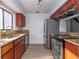 Kitchen featuring stainless steel appliances, wood cabinets, and light-colored countertops at 4765 Capri Pl # 209, Orlando, FL 32811
