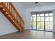 Bright living room featuring wood stairs, modern flooring, and sliding glass doors to an enclosed balcony at 4765 Capri Pl # 209, Orlando, FL 32811