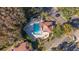 Overhead shot of a sparkling community pool surrounded by trees and lounge chairs at 4765 Capri Pl # 209, Orlando, FL 32811