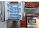 Stainless steel refrigerator with door open to reveal lighted shelves and bins at 4765 Capri Pl # 209, Orlando, FL 32811