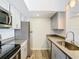 Modern condo kitchen with stainless steel appliances and light gray cabinets at 5144 Conroy Rd # 35, Orlando, FL 32811