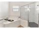 Bright bathroom boasts marble-look tile, separate tub, and glass-enclosed shower at 530 Sanctuary Blvd, Winter Haven, FL 33881