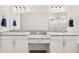 Bright bathroom featuring dual sinks with granite countertops, white cabinets, and a large mirror at 530 Sanctuary Blvd, Winter Haven, FL 33881