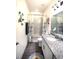 Well-lit bathroom with granite countertops and decorative floral shower curtain at 530 Sanctuary Blvd, Winter Haven, FL 33881