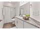 Bright bathroom features a shower and tub combination with marble tile surround and granite countertops at 530 Sanctuary Blvd, Winter Haven, FL 33881