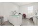 Bright craft room with ample workspace, rolling storage, wood-look floors and natural light at 530 Sanctuary Blvd, Winter Haven, FL 33881