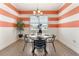 Dining area features modern light fixture, decor, and orange stripes on the accent wall at 530 Sanctuary Blvd, Winter Haven, FL 33881