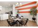 Dining area features modern light fixture, decor and table set for dinner adjacent to open concept kitchen at 530 Sanctuary Blvd, Winter Haven, FL 33881