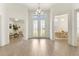 Bright foyer with grand chandelier, double entry doors, and an open floor plan at 530 Sanctuary Blvd, Winter Haven, FL 33881