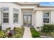 Elegant front entrance with glass double doors, enhanced by decorative plants and tasteful landscaping at 530 Sanctuary Blvd, Winter Haven, FL 33881