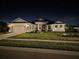 Charming single-story home boasts well-manicured lawn and tasteful landscaping at night at 530 Sanctuary Blvd, Winter Haven, FL 33881