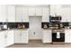 Modern kitchen with white cabinetry, dark backsplash, granite countertops, and stainless steel appliances at 530 Sanctuary Blvd, Winter Haven, FL 33881